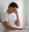 A man with migraines holds her hand by his nose in the bed. A man with migraines holds her hand by his nose in the bed.